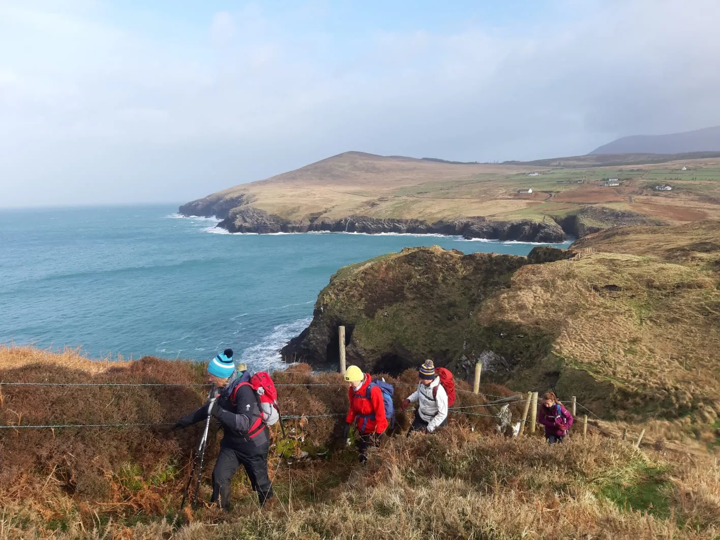 Walkers on a coastal path above the sea