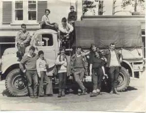 Black and white photo of club members gathered around an old truck