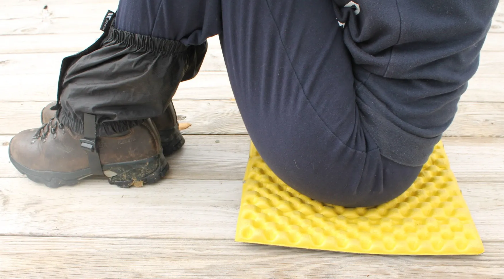 A walker sitting on a yellow folding sit mat